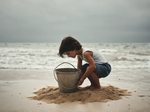 sand bucket,building sand castles,sand timer,playing in the sand,fetching water,woman at the well,sand castle,child playing,head stuck in the sand,sandcastle,wishing well,sandbox,water funnel,sand,water pollution,salt harvesting,water withdrawal,sand sculpture,footprints in the sand,teaching children to recycle,Photography,Documentary Photography,Documentary Photography 08