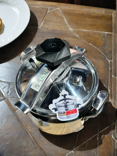 kitchen scale,cigarettes on ashtray,clothes iron,cooktop,gas stove,cake stand,ceramic hob,portable stove,helmet plate,coffee wheel,vintage dishes,music instruments on table,stack of plates,plate shelf,dish storage,pizza cutter,black plates,ashtray,serving tray,cd player