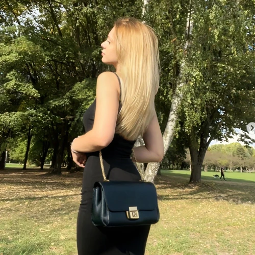 shoulder bag,girl from the back,girl in a long dress from the back,girl from behind,kelly bag,in the park,walk in a park,golfvideo,golf course background,black dress with a slit,bag,handbag,outdoors,volkswagen bag,yellow purse,purse,blonde girl with christmas gift,suitcase in field,blonde woman,half profile
