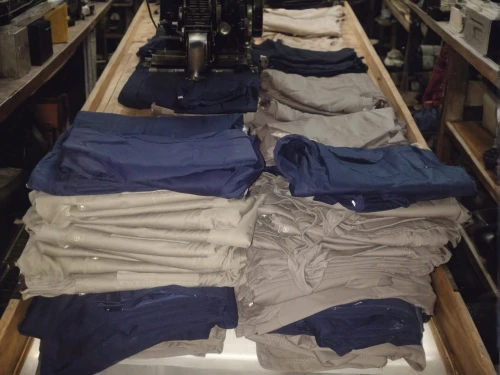 garment racks,clotheshorse,wardrobe,walk-in closet,carpenter jeans,polo shirts,boats and boating--equipment and supplies,carts,chef's uniform,turning cloths,garments,a drawer,linen,shirts,truck bed part,closet,inventory,clothes,clothing,boat yard