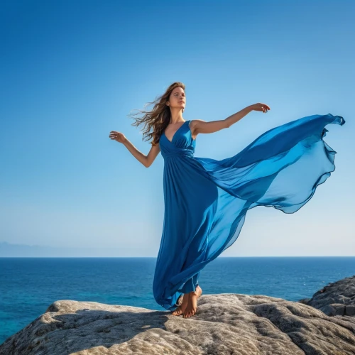 celtic woman,girl in a long dress,gracefulness,blue enchantress,blue dress,aphrodite's rock,girl on the dune,mazarine blue,blue moment,flamenco,the wind from the sea,shades of blue,portrait photography,valse music,passion photography,long dress,divine healing energy,lycian,greek myth,karpathos,Photography,General,Realistic