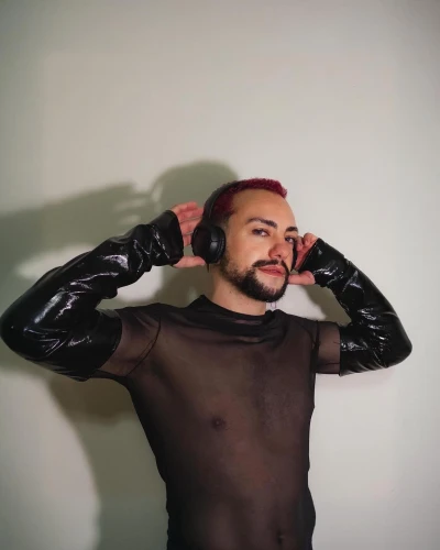 photo session in bodysuit,harness,leather,wetsuit,a wax dummy,male model,bodysuit,latex,pvc,v,rubber doll,rubber,latex clothing,breasted,bodyworn,spice up,red background,streampunk,black leather,dark red