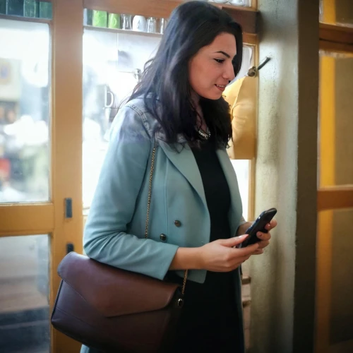 woman holding a smartphone,mobile device,mobile banking,woman at cafe,holding ipad,mobile tablet,businesswoman,leather suitcase,tablets consumer,business woman,woman in menswear,the app on phone,messenger bag,e-book reader case,bussiness woman,yellow purse,mobile devices,on the phone,travel woman,shopper