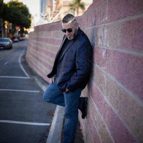 silver fox,man on a bench,curb,album cover,palo alto,brick wall,los angeles,yellow brick wall,beatnik,brick wall background,san francisco,sanfrancisco,blue-collar,male model,red brick wall,streets,bolero jacket,brick background,carpenter jeans,west hollywood