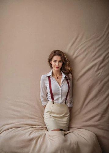 bed,stana,topanga,woman on bed,girl in bed,pantsuit,vogue,on the couch,laying,white and red,rose white and red,reclining,pillows,sofa,arms crossed,lying down,elegant,instyle,elle,cushion