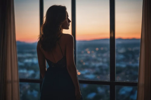 woman silhouette,girl in a long dress,girl in a long dress from the back,silhouette,window view,soir,a girl in a dress,nightdress,romantic portrait,in the evening,evening atmosphere,window to the world,romantic look,overlooking,evening dress,nightgown,coucher,sunset,bedroom window,sunset glow,Photography,General,Cinematic