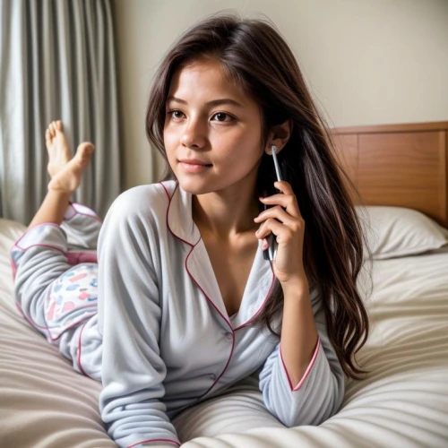 on the phone,woman holding a smartphone,phone call,phonecall,woman on bed,girl in bed,telephone handset,telecomasia,phonecalls,telephonic,calling,pyjama,relaxed young girl,voicestream,handset,asian woman,man talking on the phone,telefono,handphones,speakerphone