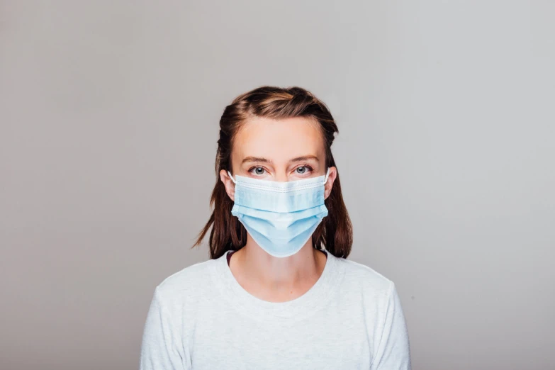 woman in a white shirt wearing a surgical mask
