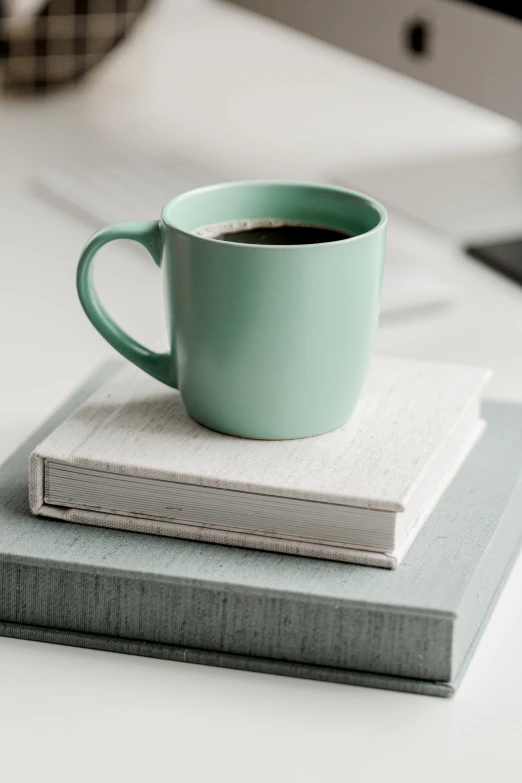 a cup of coffee on top of some books