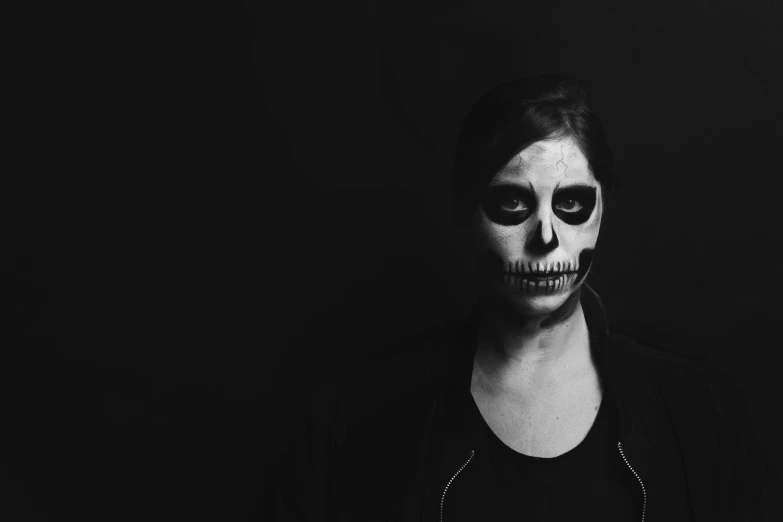 the girl is painted like a skeleton for halloween