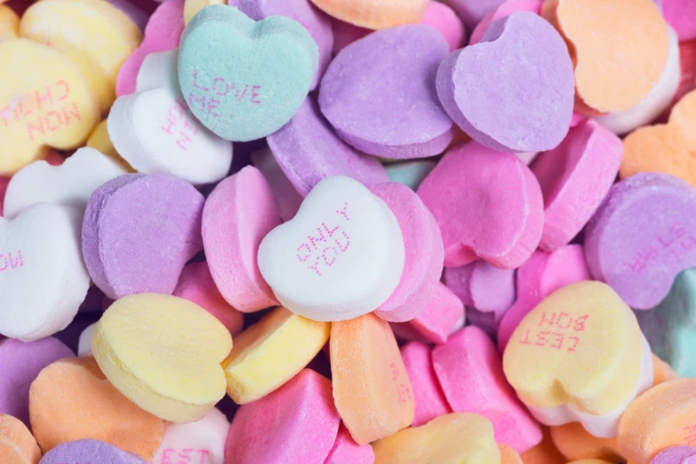 a pile of candy hearts with writing on them