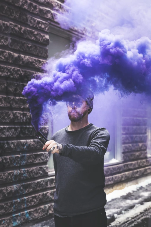 a man with purple smoke on the street