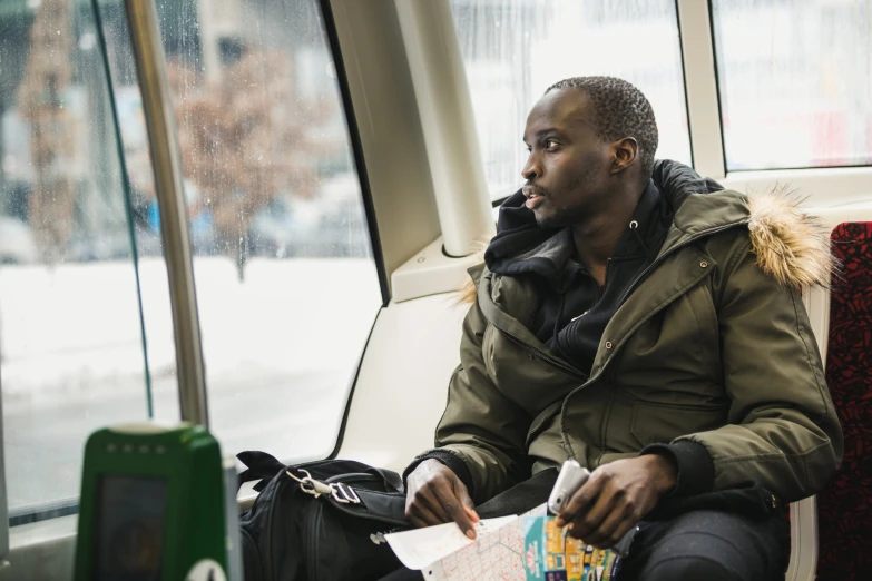 a young man sitting on a bus looks to his right