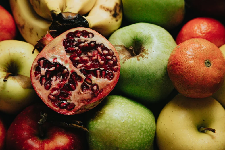 a ripe pomegranate sits atop of the whole fruit