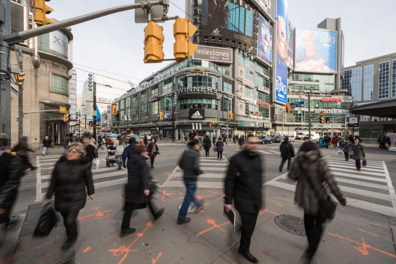 many people are crossing the street on a crosswalk