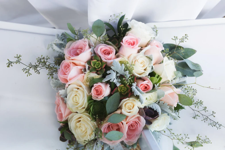 bridal bouquet on the white couch with white satin bow