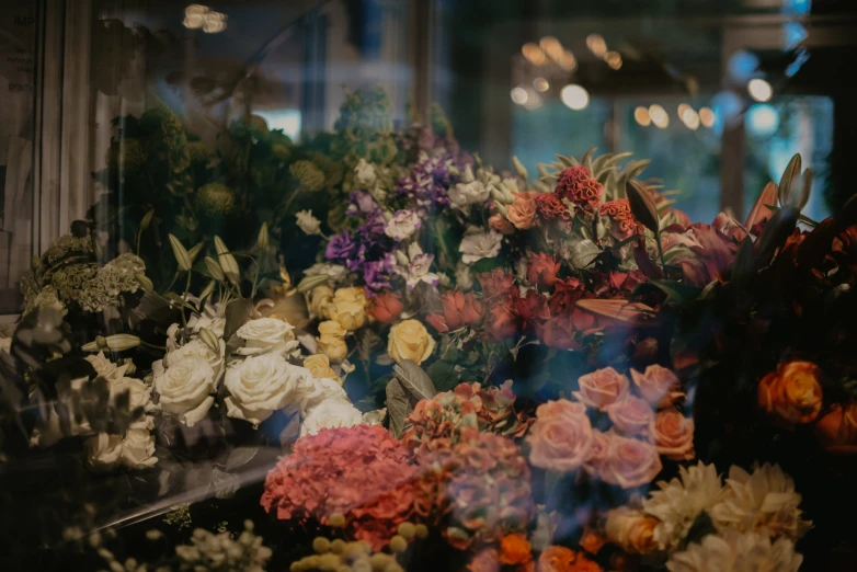 an array of flowers on display in a glass case