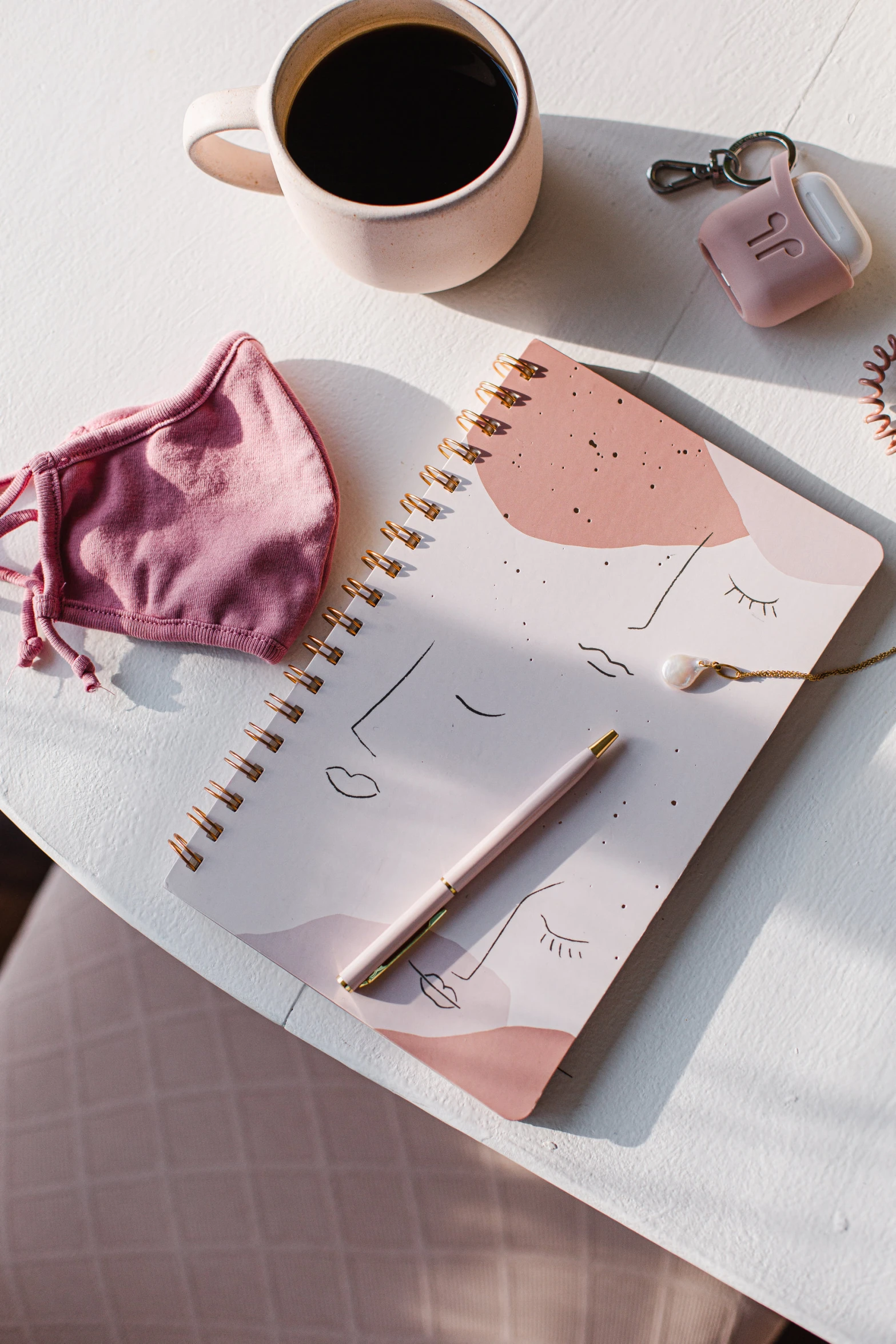 a pink shirt and some pens on a table