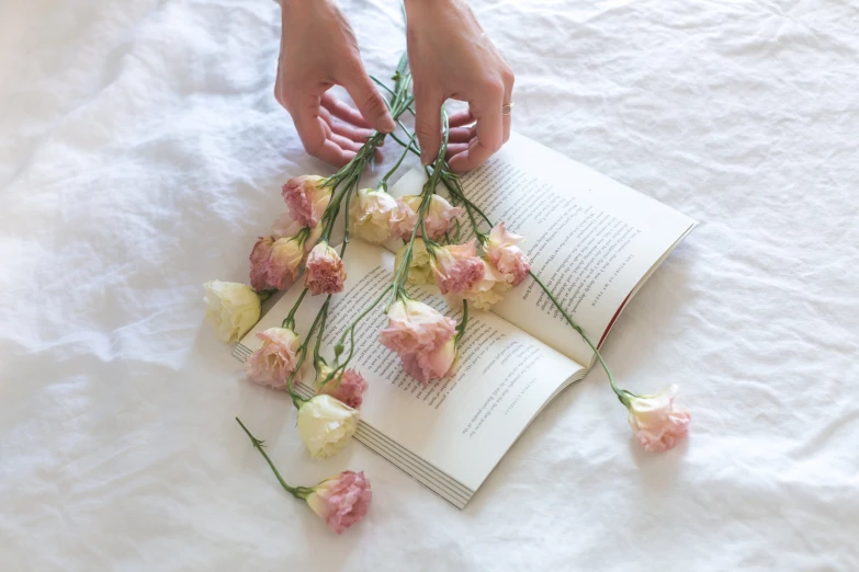 someone arranging flowers on the bed by their hands