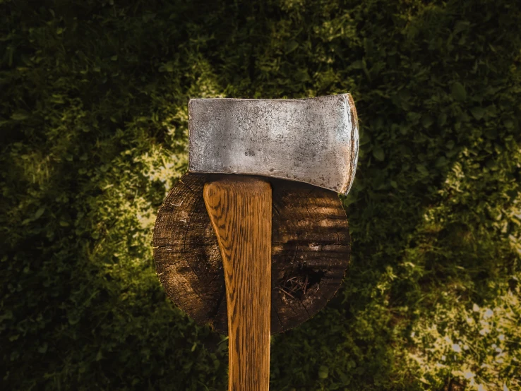 an axe stuck inside of a small piece of wood