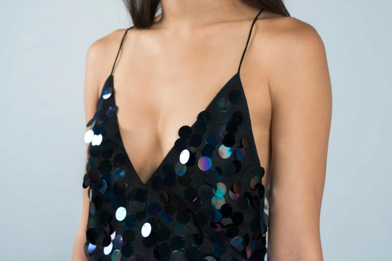 a girl is wearing a shiny black dress with sequins