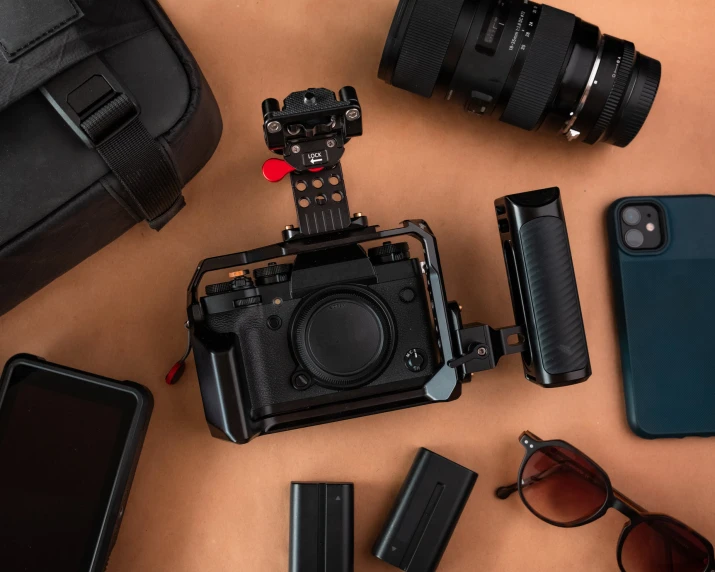 a camera, cellphone and batteries are laid out in the shape of a box