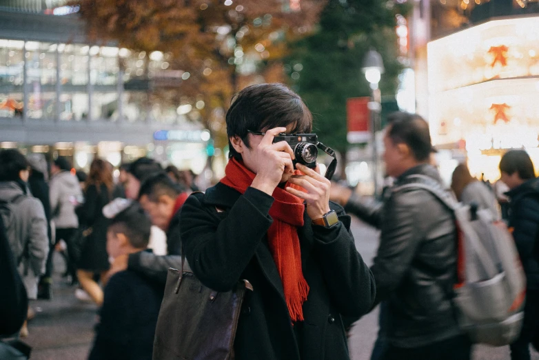 a person taking a pograph of a busy city street