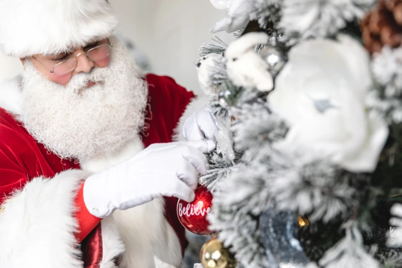 a man wearing a santa suit and holding a christmas ornament