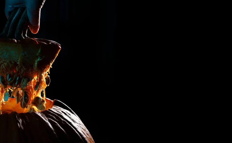 the hands of a young man cooking a pumpkin