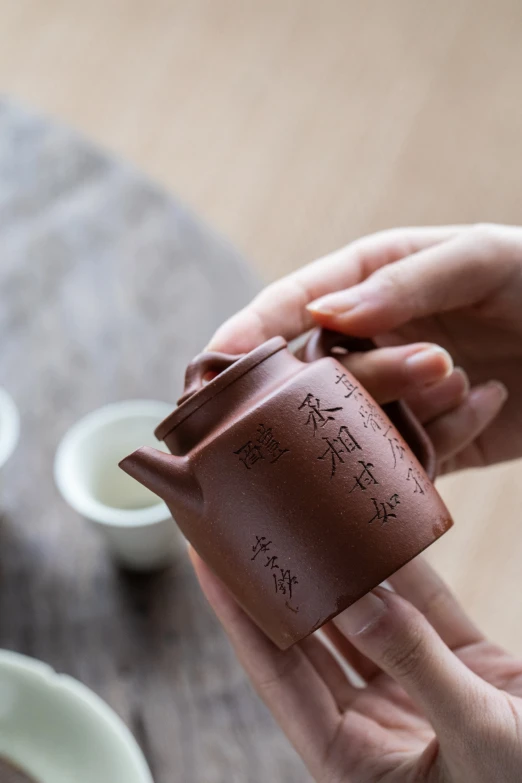 a person putting soing in a cup with writing on it