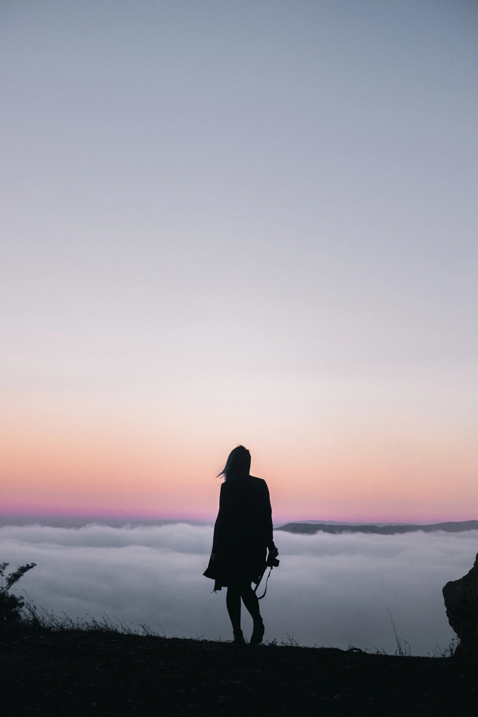 two people standing with their backs to the camera at sunrise