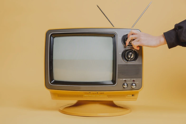 a person touching the top of a small tv