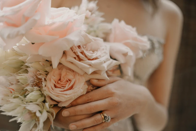 a woman is holding her bouquet in both hands