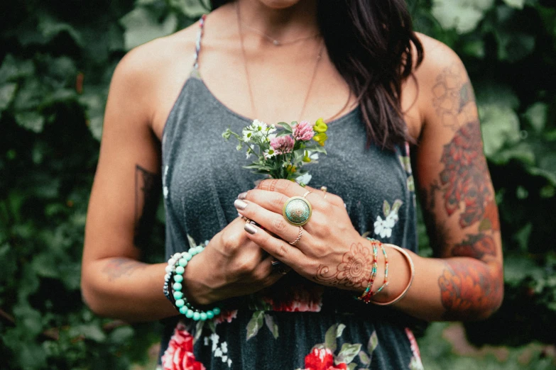 a woman holding flowers wearing a black tank top