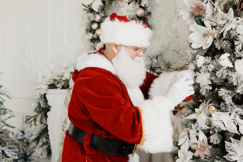 a man dressed as santa clause putting up the tree