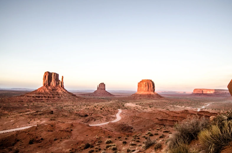 a dirt road running through an area with mountains in the background