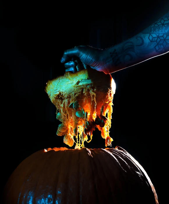 a man holding a large, melted orange pumpkin