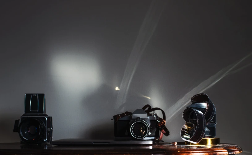 a group of three old fashioned cameras and one antique camera