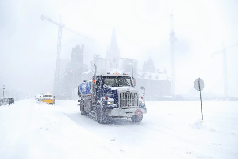 a snowy city with cars and buses on the street