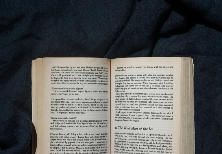 an open book with pages not in read, on a blue cloth