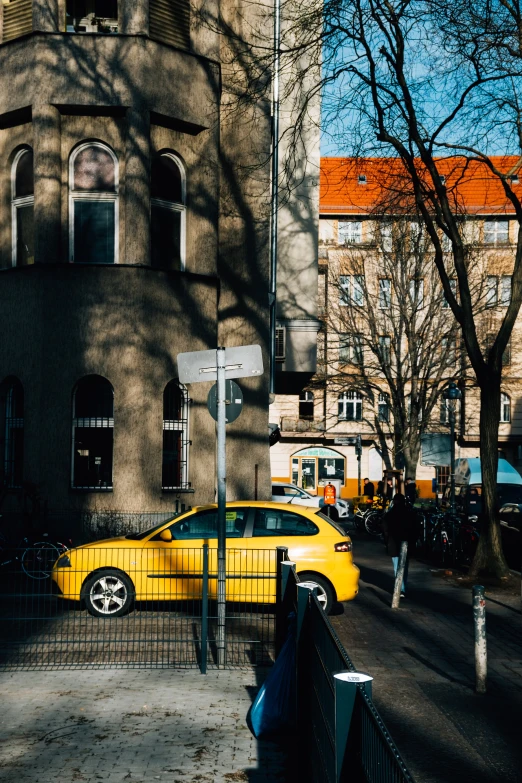 a small yellow car parked near a building