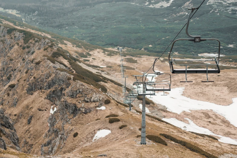 a ski lift going down a hill with snow on the ground