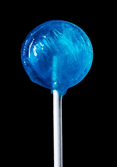 blue lollipop on stick on black background