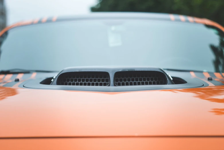 an orange dodge parked in a parking lot