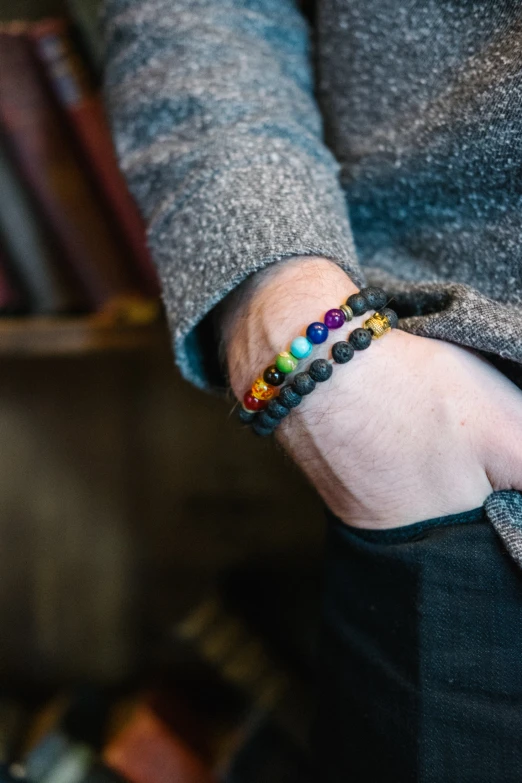 the person is wearing several beads in their hand