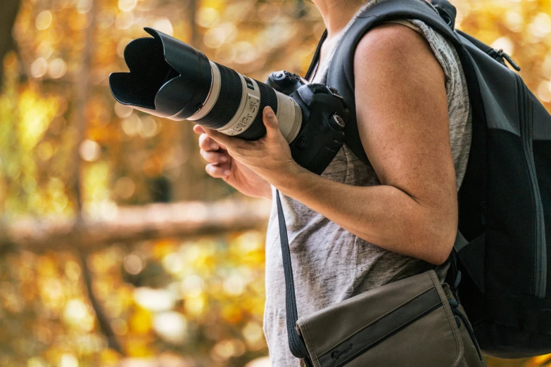 a woman is holding up an image camera with her hands