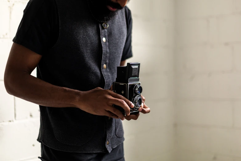 man standing with his hand on the camera