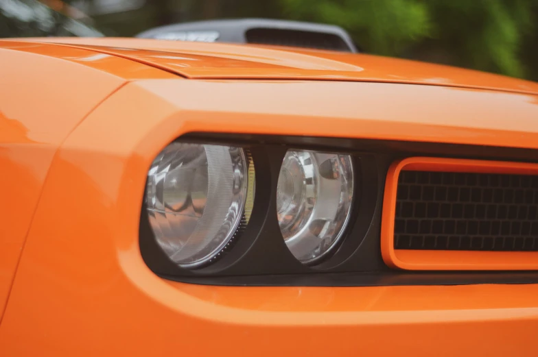 the front lights and grille of an orange sports car