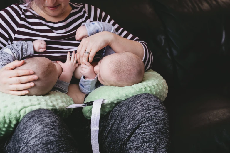 a woman holding onto a baby in her lap