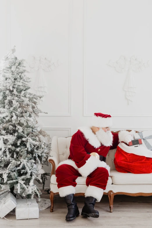 a person sitting on a bench in front of a christmas tree